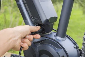 A hand showing how to charge electric bike