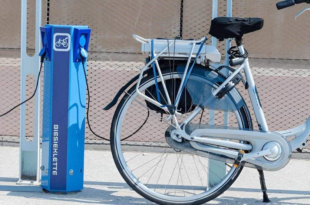An ebike is being charged on a public charging place beside a street