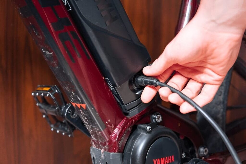 A person is fixing plug into an electric bike to show how to charge an electric bike