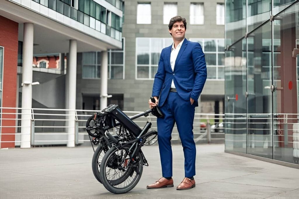 A man is standing with folding electric bike beside him