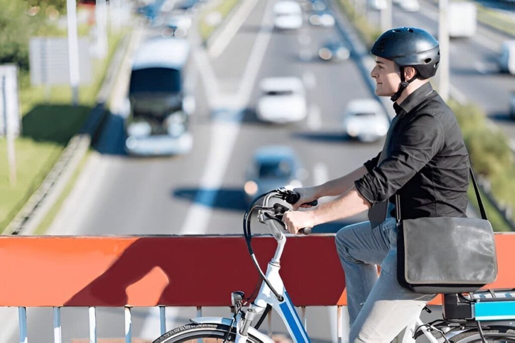 A man riding on a commuter electric bike on a city over-bridge